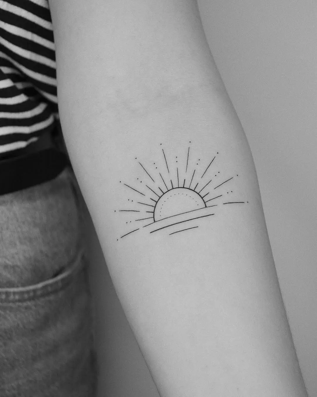 Minimalist sunrise tattoo with delicate lines