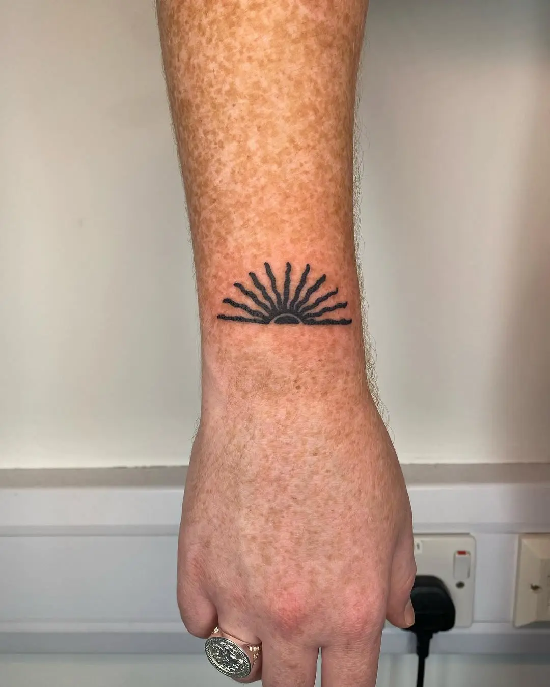 Minimalist sunrise tattoo radiates positive energy