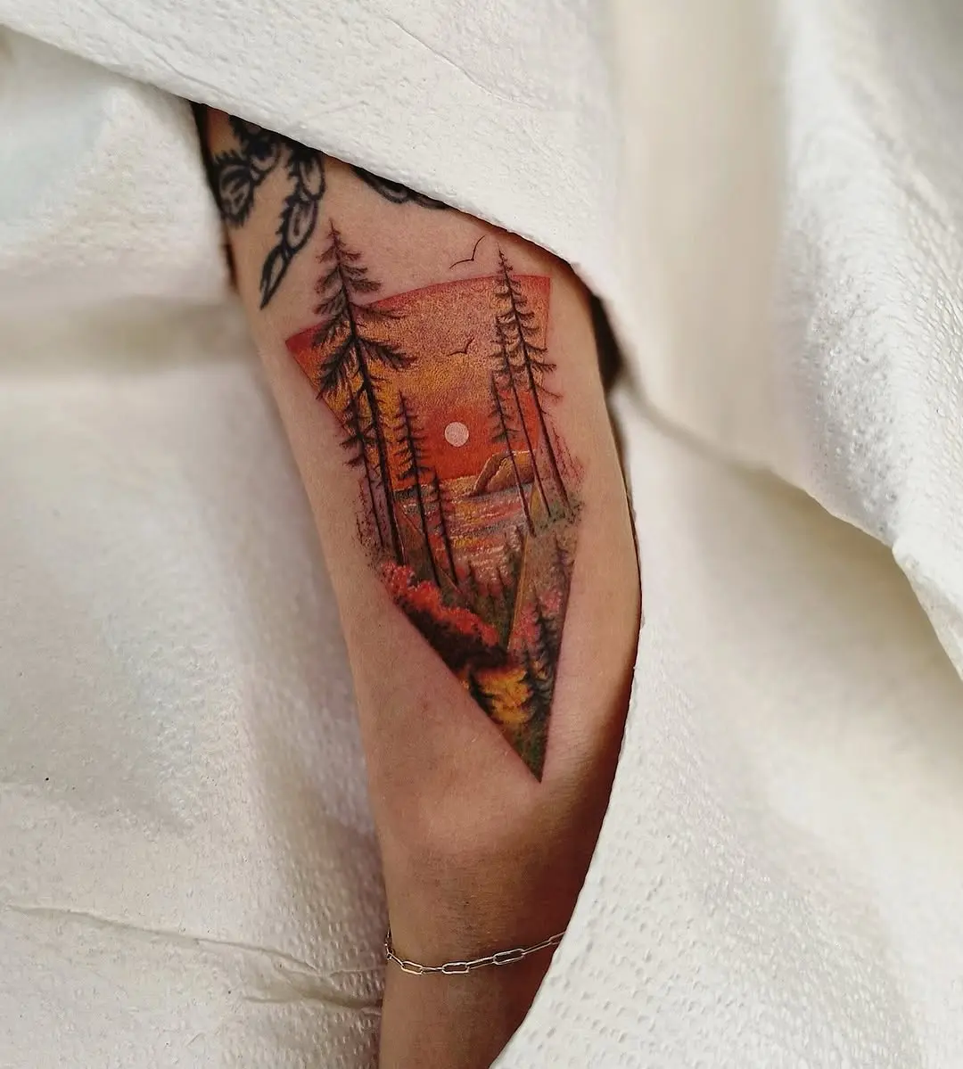 Vibrant sunrise tattoo with nature elements