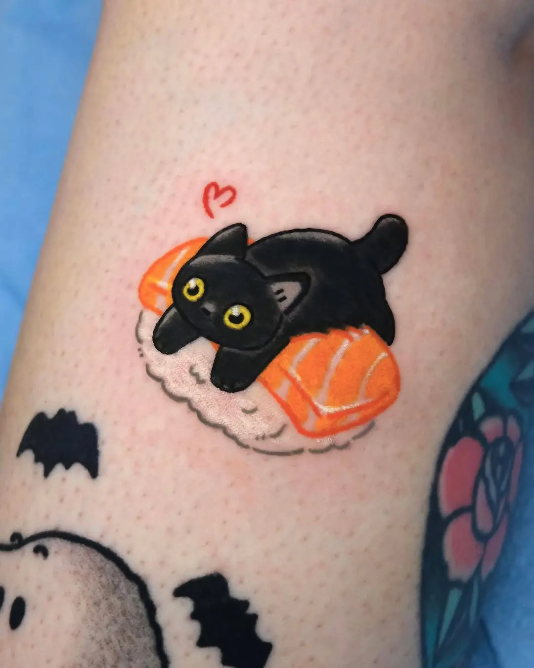Adorable kitty lounging on sushi slice tattoo