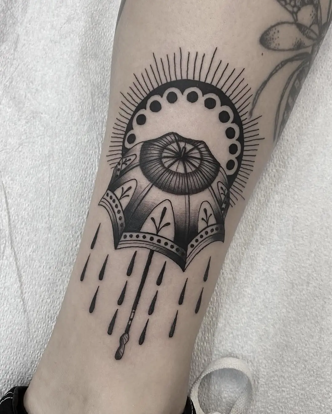 Intricate umbrella tattoo with radiant sun