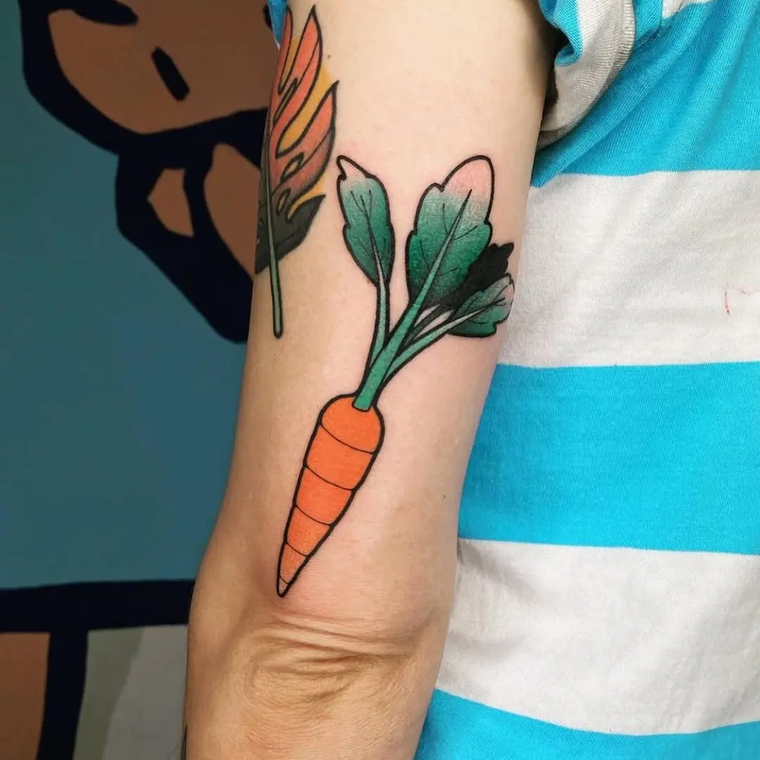 Vibrant carrot tattoo with leafy greens