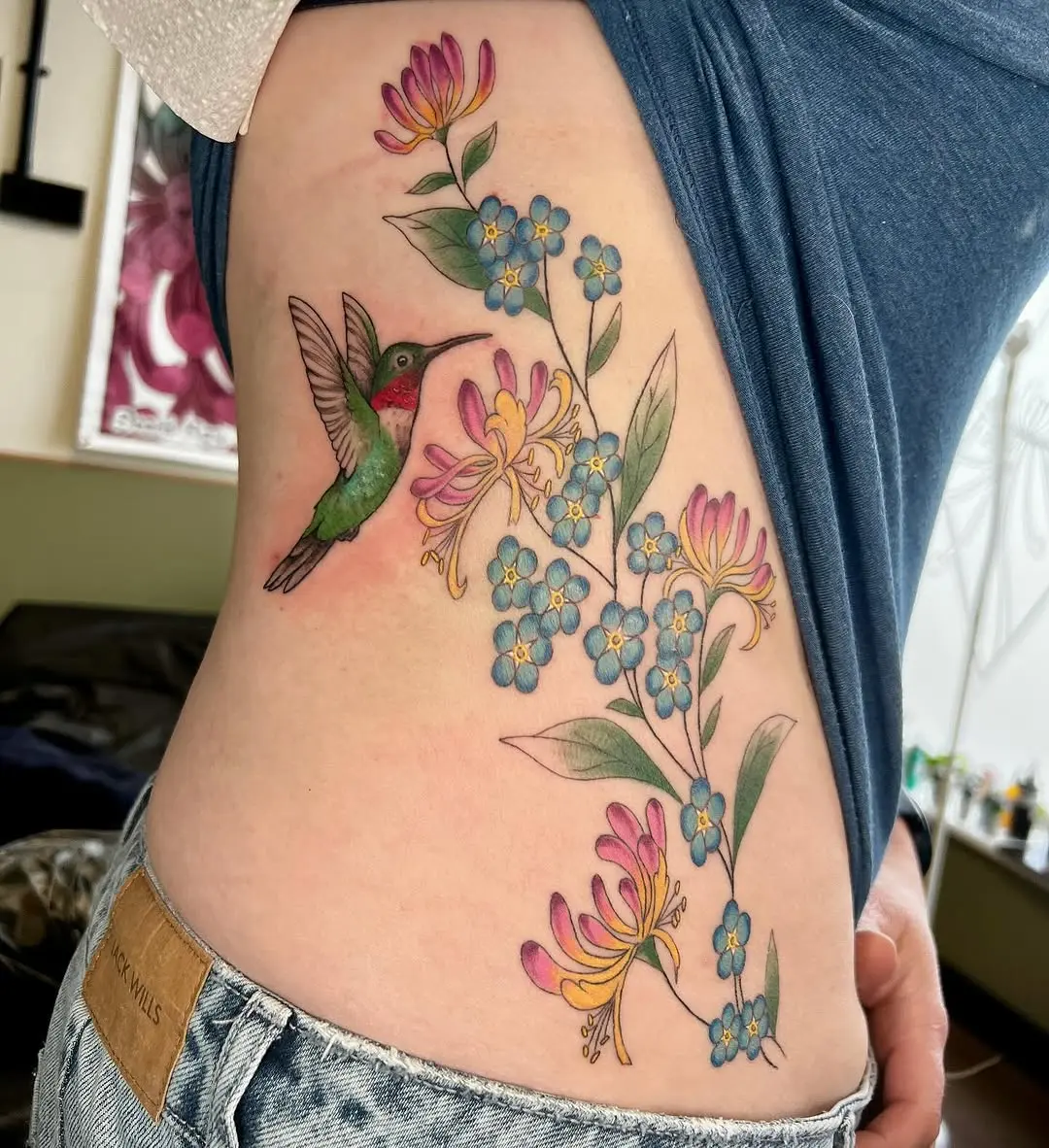 Vibrant honeysuckle and hummingbird tattoo design