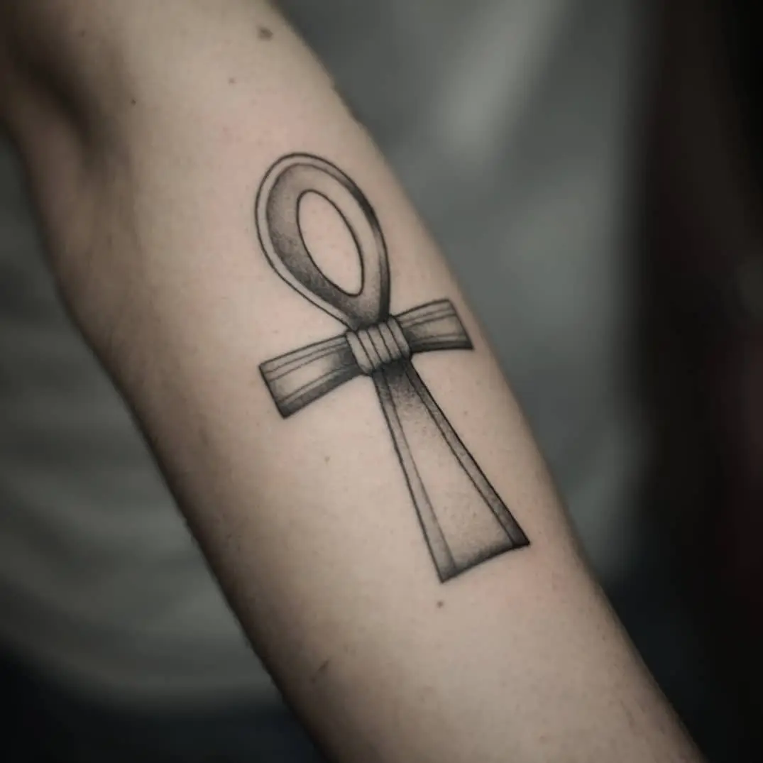 Stylized ankh tattoo with intricate detailing
