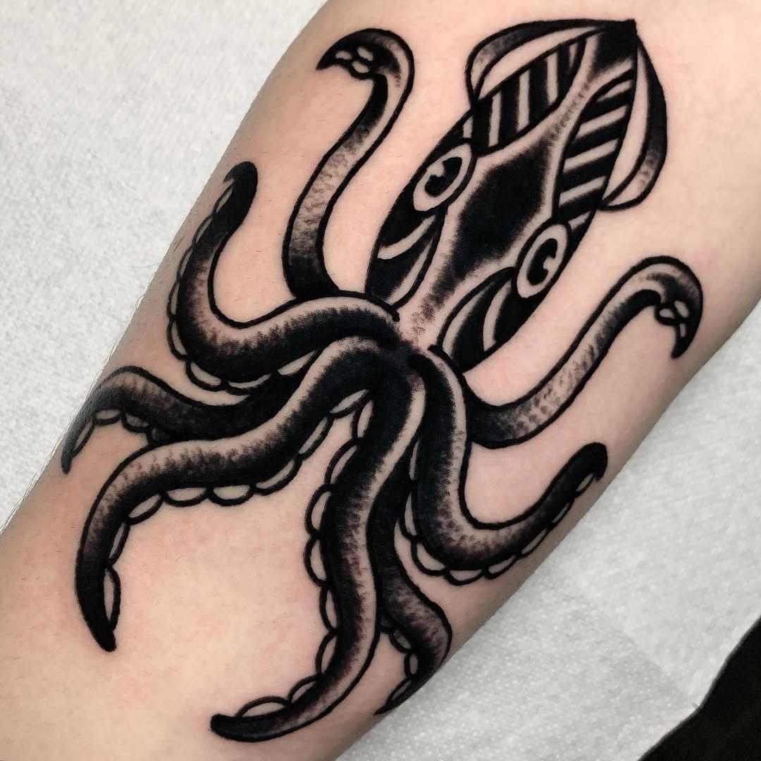 Intricate black squid tattoo design on arm