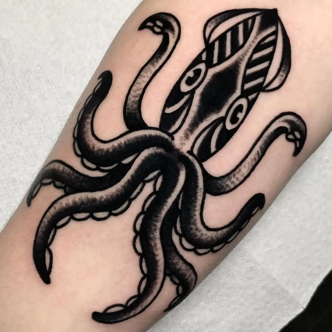 Intricate black squid tattoo design on arm
