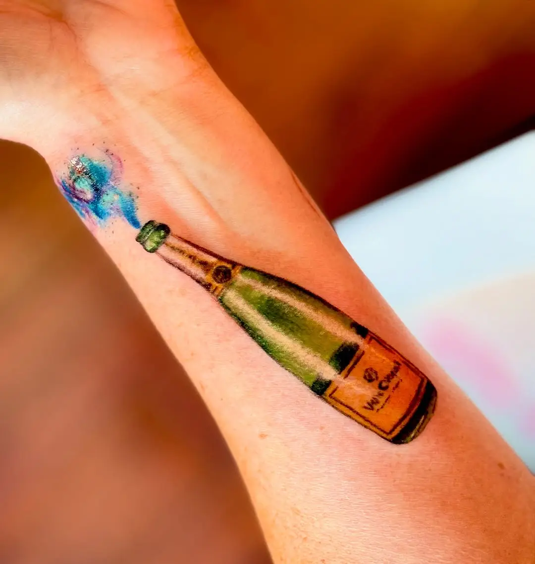 Vibrant champagne bottle tattoo celebrating life.