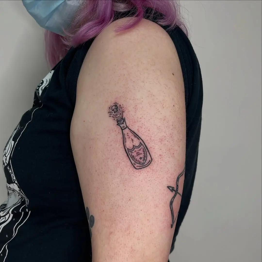 Charming champagne bottle tattoo design.