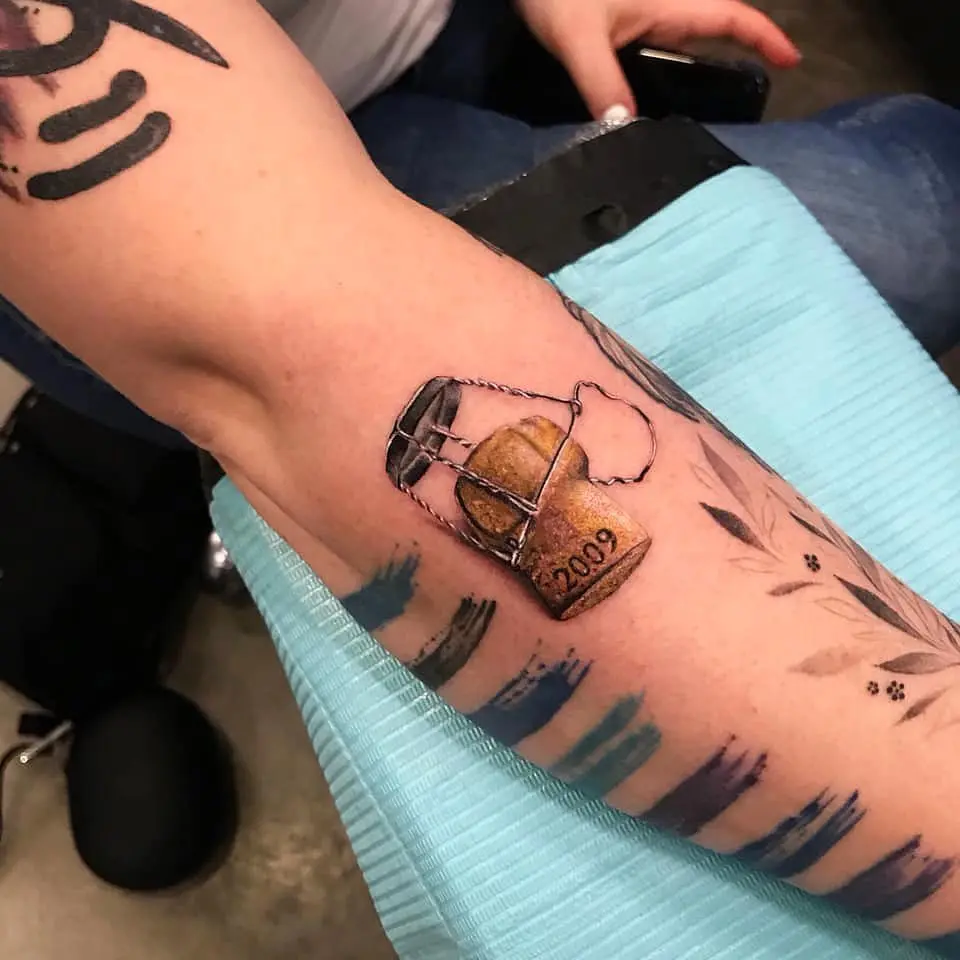 Unique champagne cap tattoo with a vintage touch