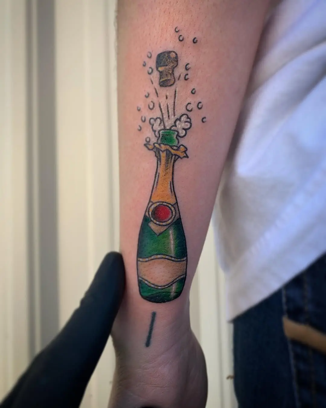 Vibrant champagne bottle tattoo with bubbles