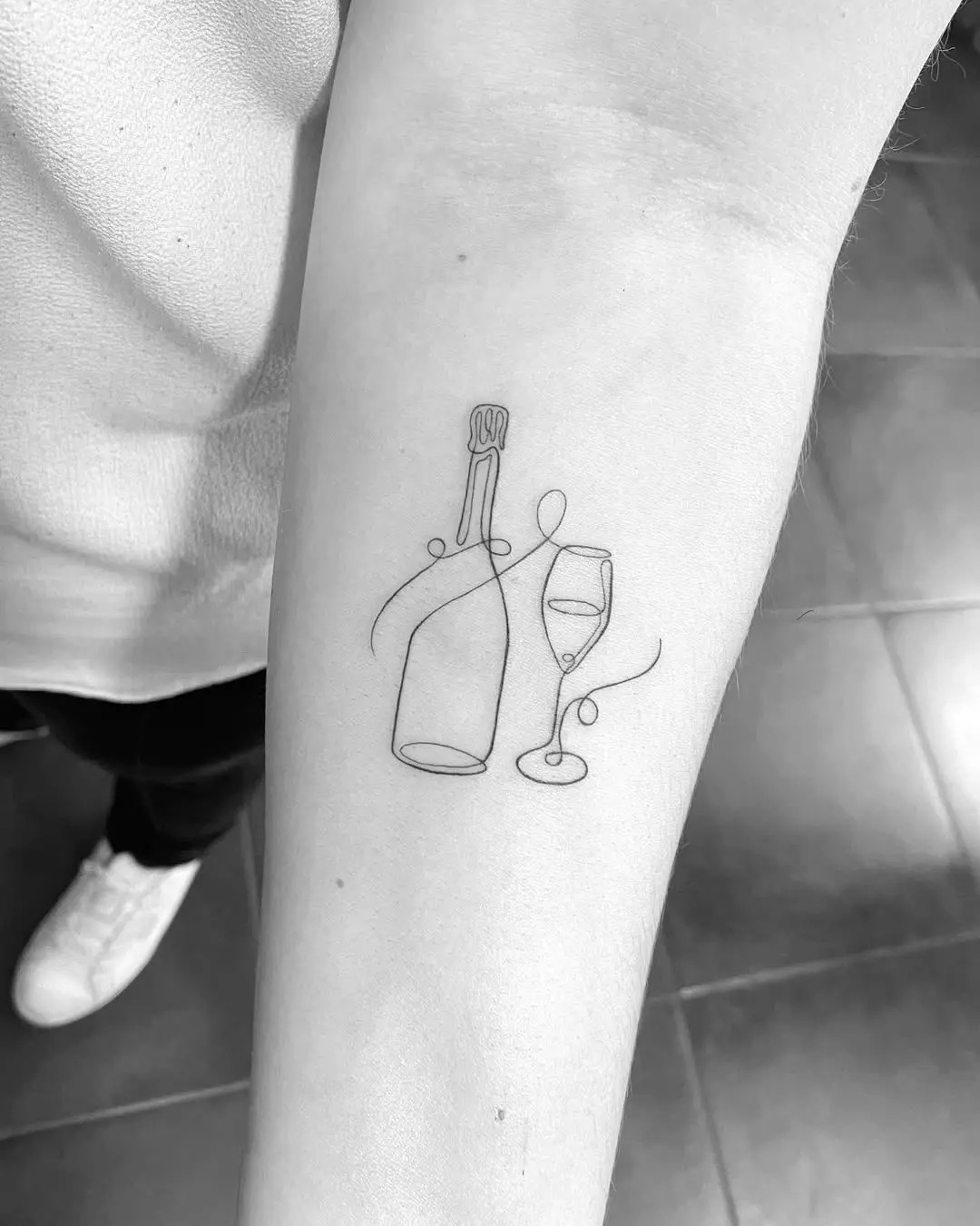 Elegant line art champagne bottle and glass tattoo