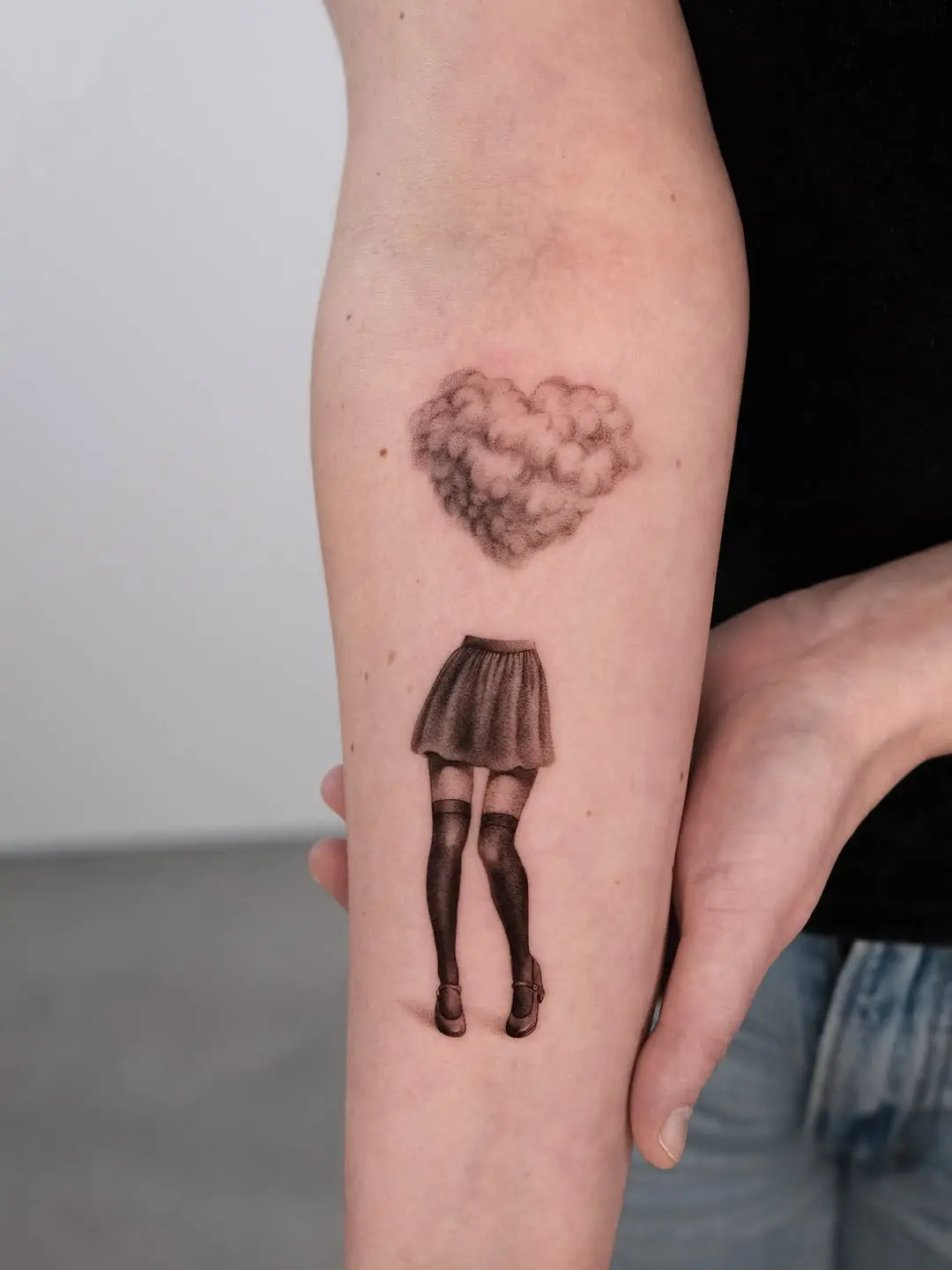 Whimsical cloud heart above stylish legs tattoo.