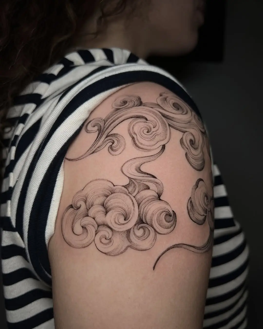 Artistic swirls of cloud tattoo on arm