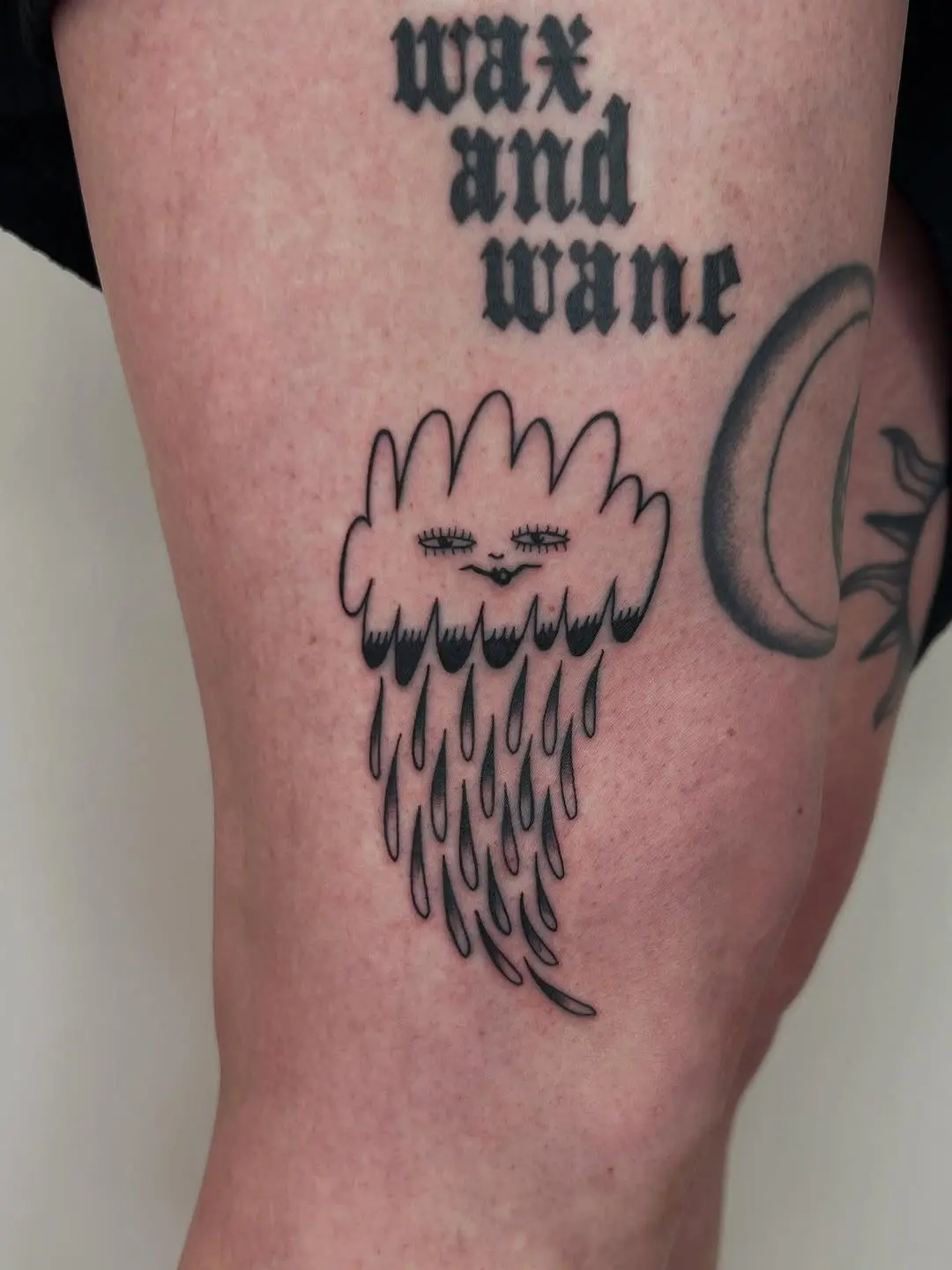 Whimsical cloud tattoo with playful raindrops