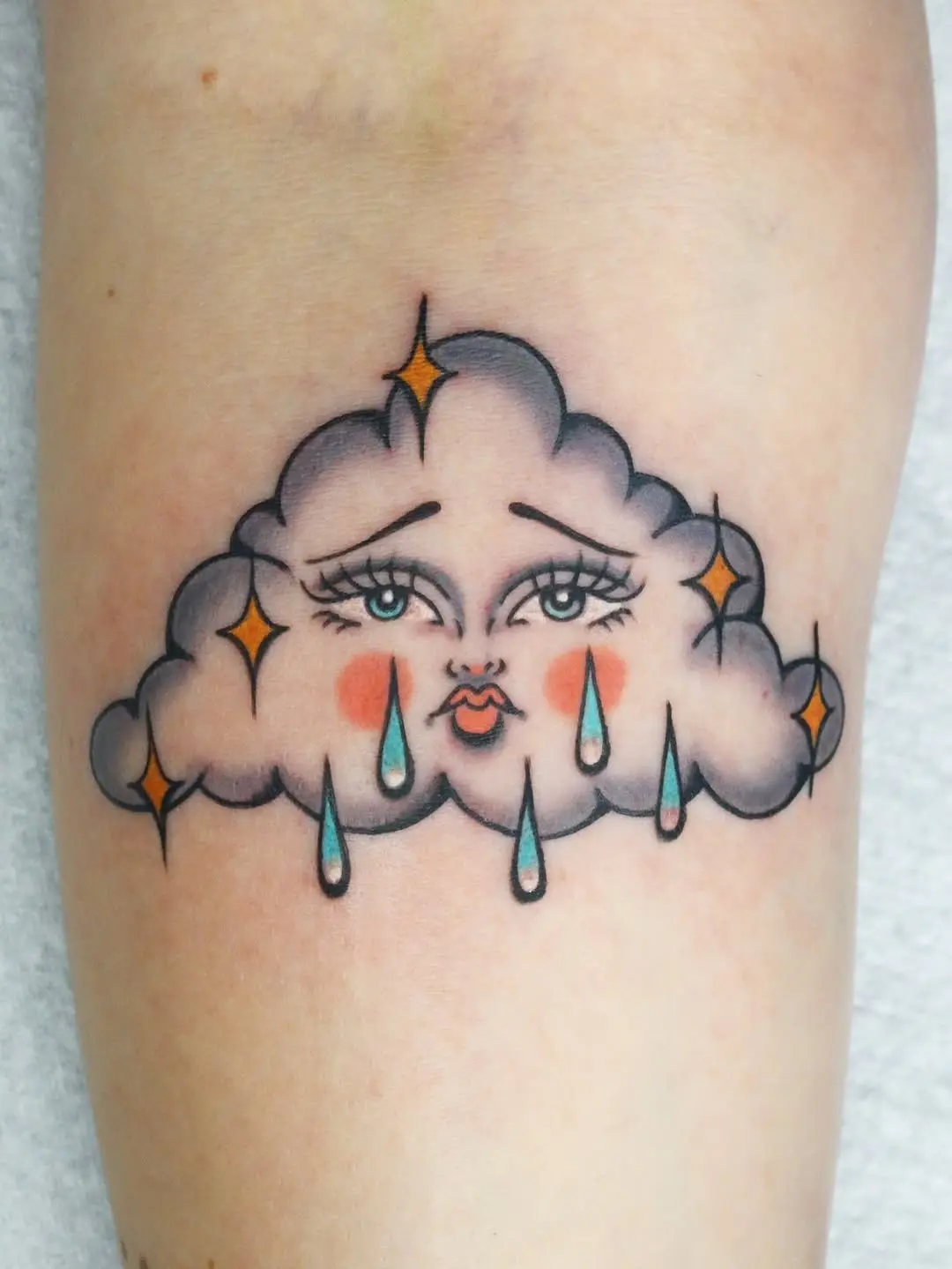 Whimsical cloud tattoo with a charming expression