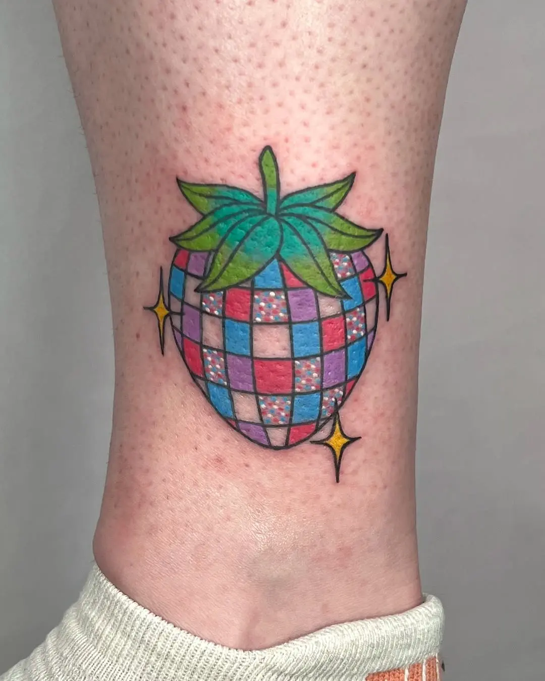 Vibrant disco-themed strawberry tattoo design