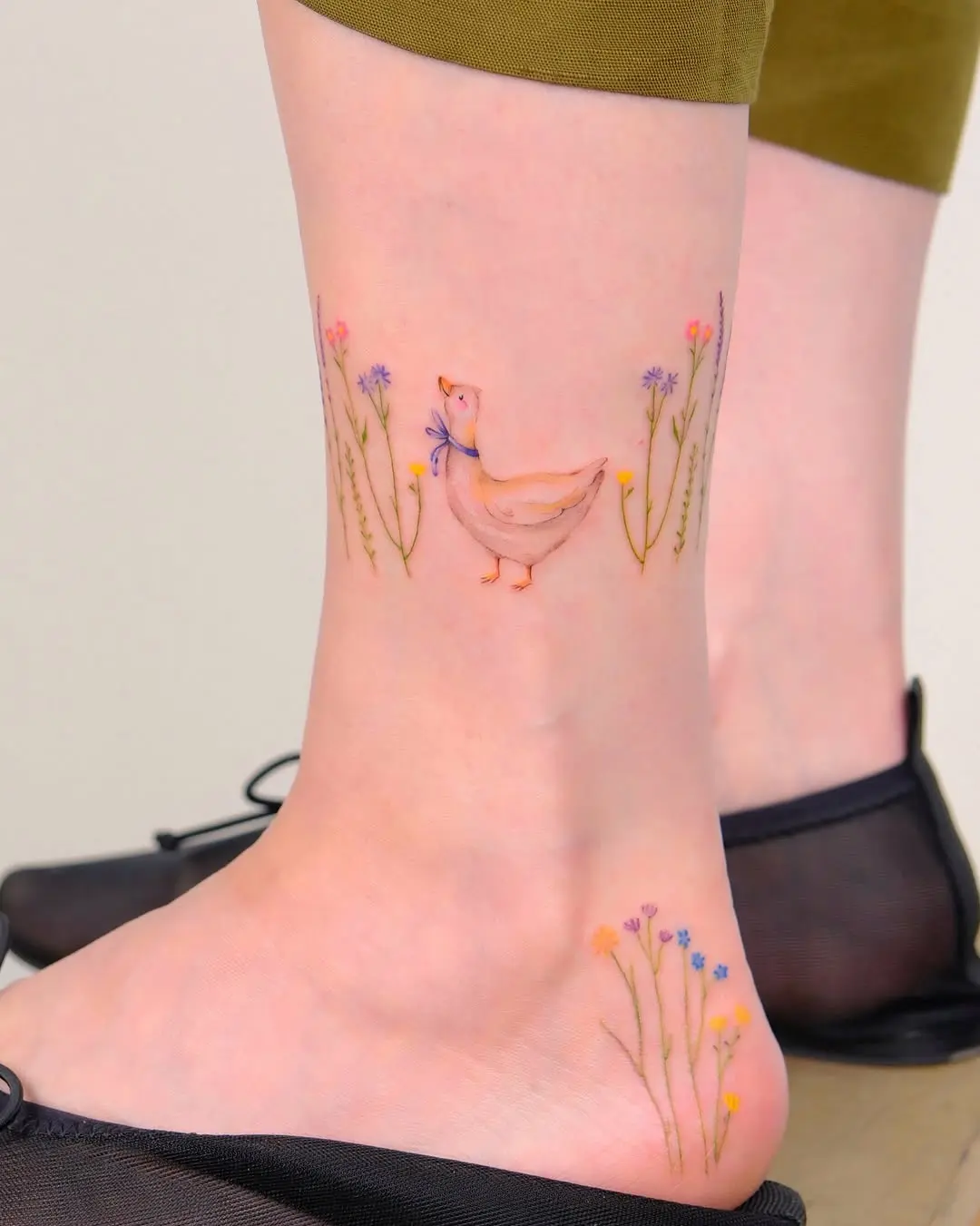 Charming duck tattoo surrounded by colorful flowers