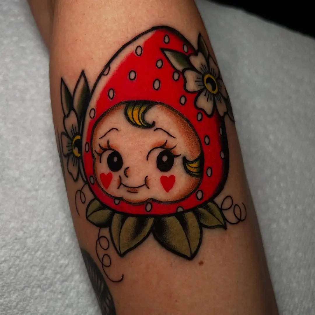 Charming strawberry character tattoo with floral elements
