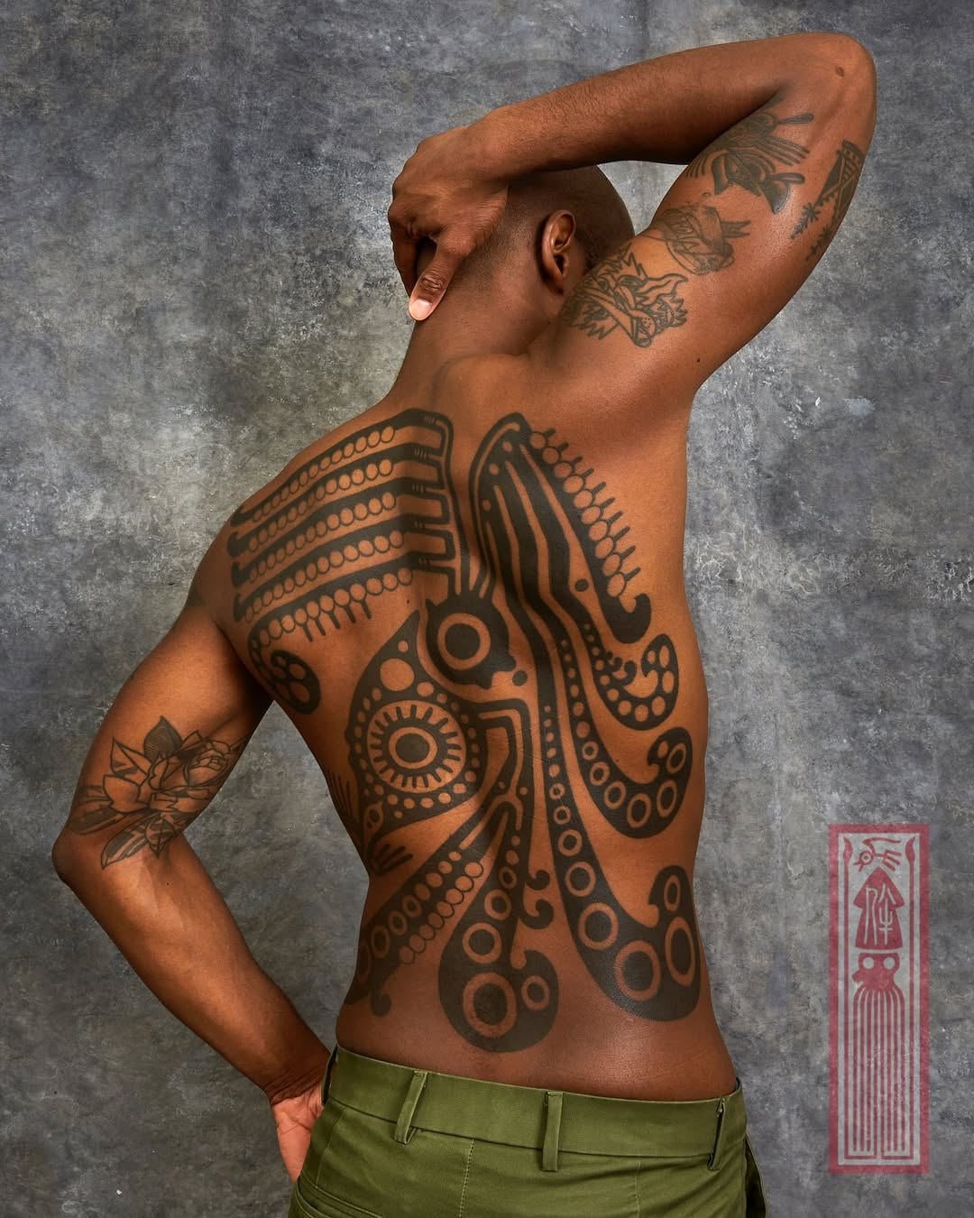 Intricate squid tattoo adorns the entire back