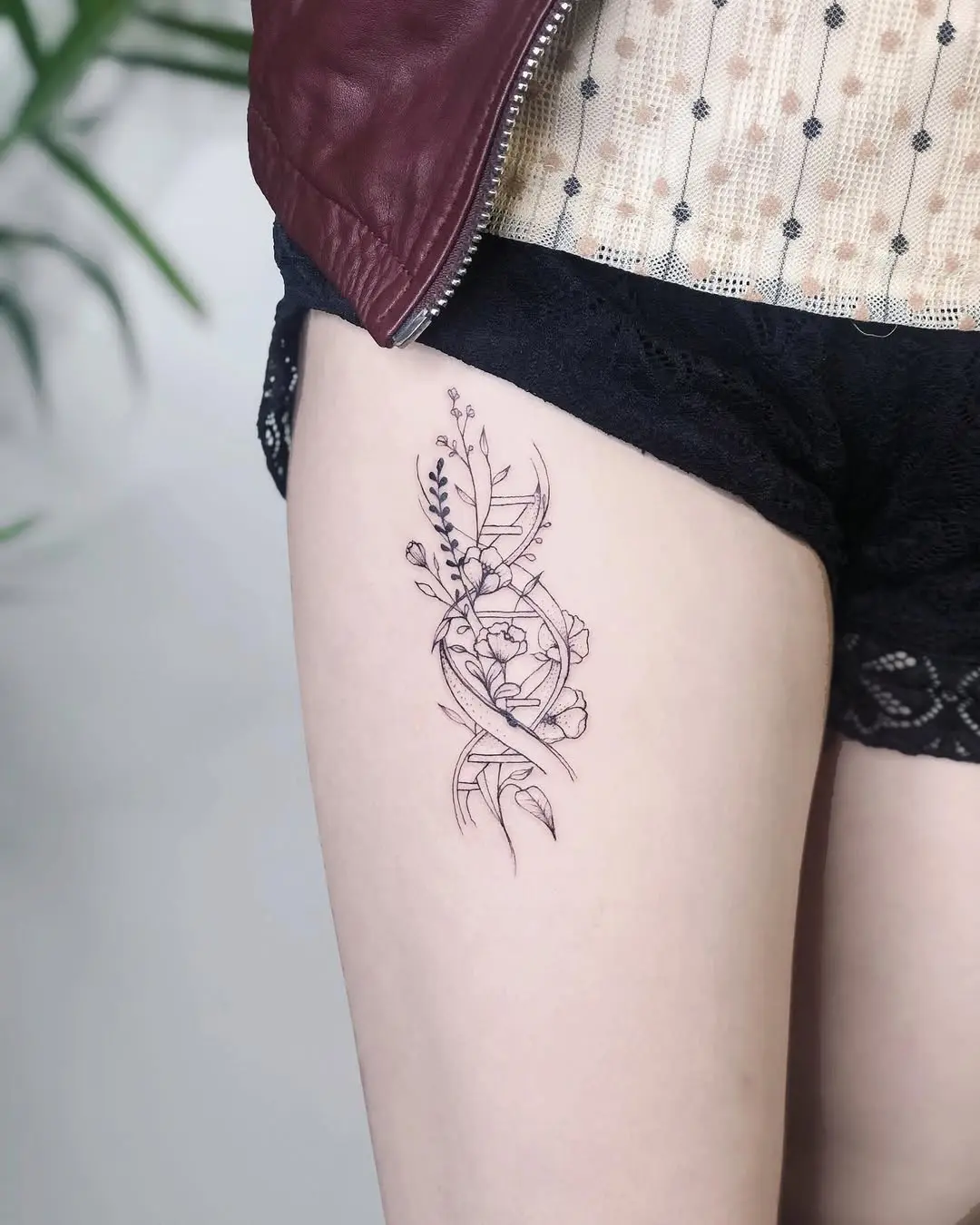 Elegant floral DNA tattoo on the thigh