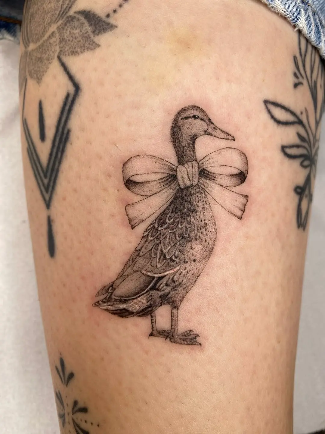 Charming duck tattoo with a playful bow