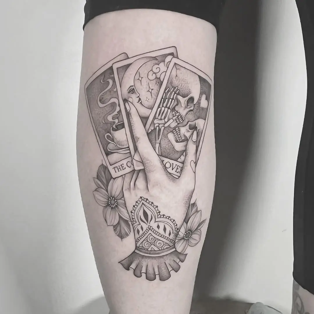Intricate hand holding tarot cards and flowers