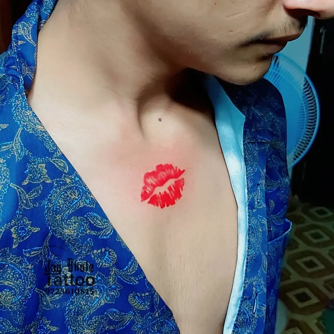 Bold kiss mark tattoo on chest