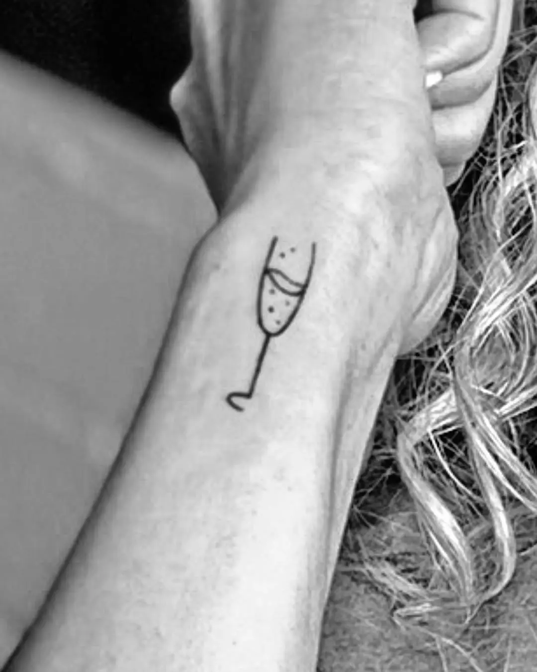 Chic champagne glass tattoo on the wrist