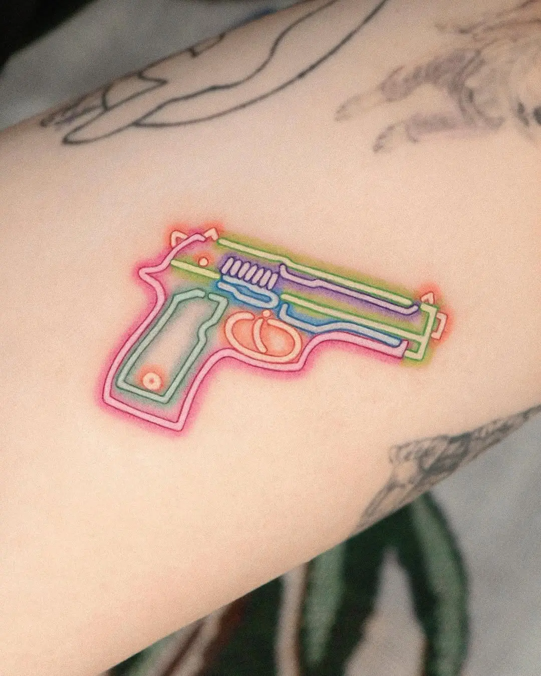 Vibrant neon gun tattoo with colorful outlines
