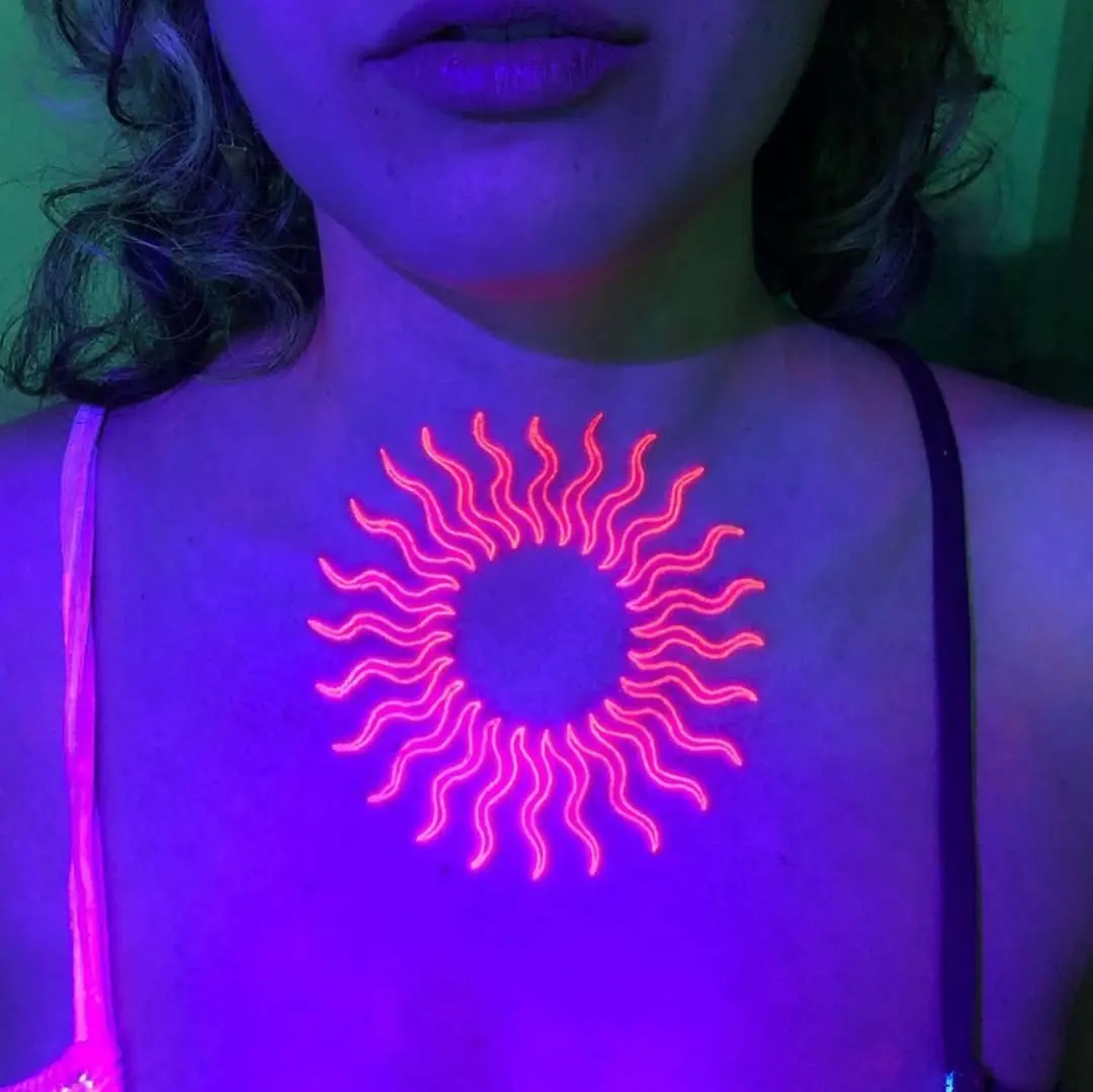 Vibrant neon sun tattoo glowing on chest