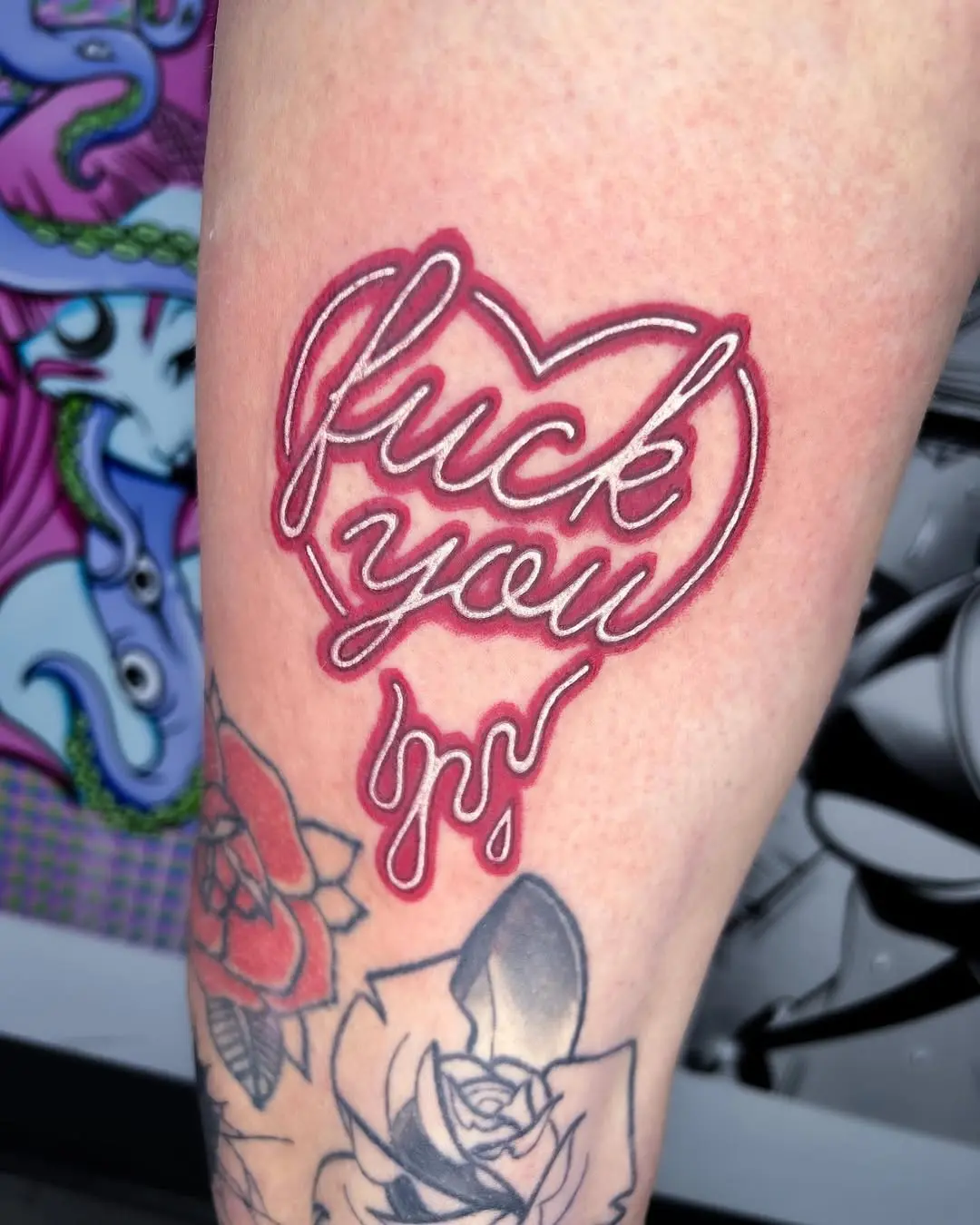 Bold neon heart tattoo with a cheeky phrase