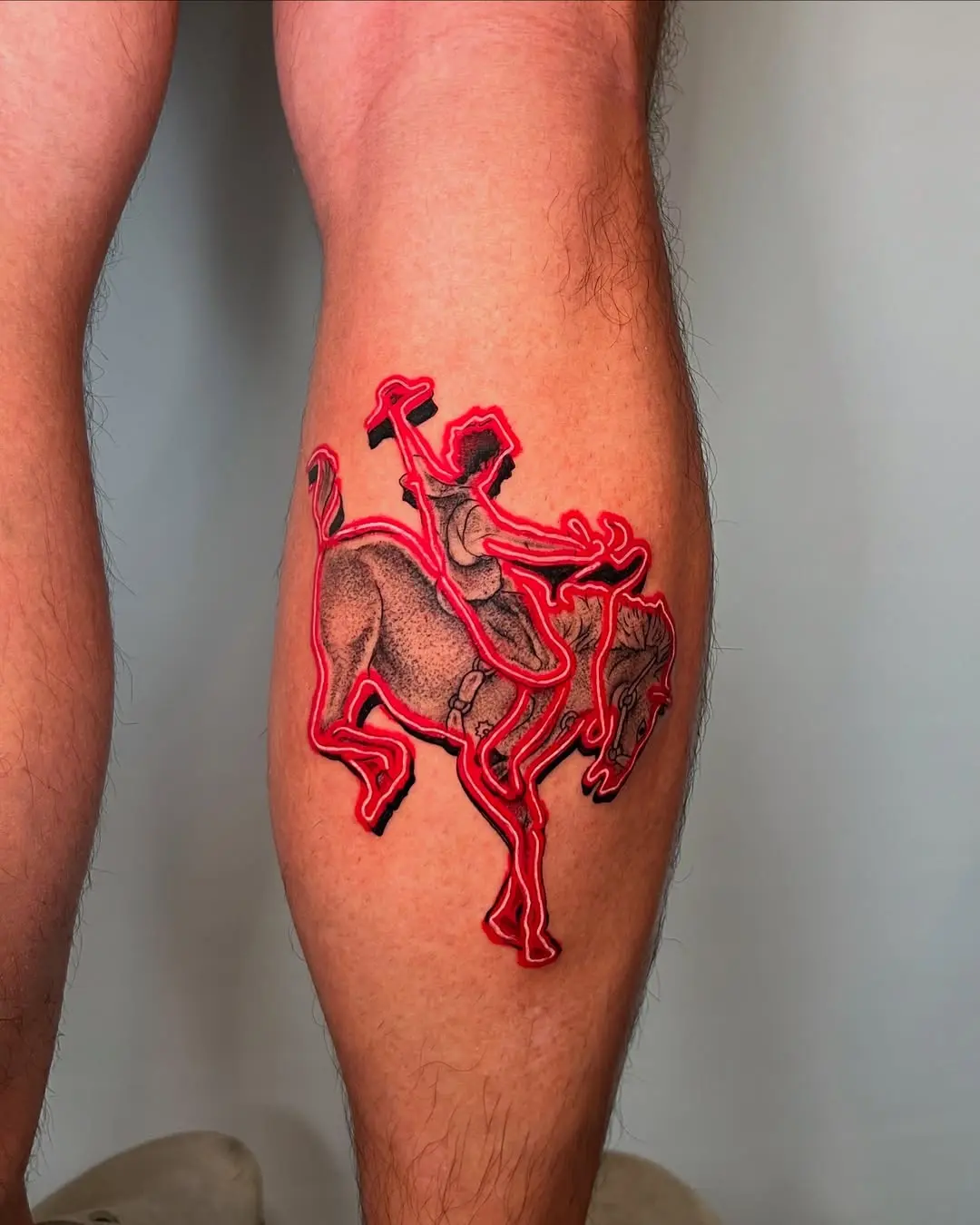 Captivating neon horse rider tattoos on leg.