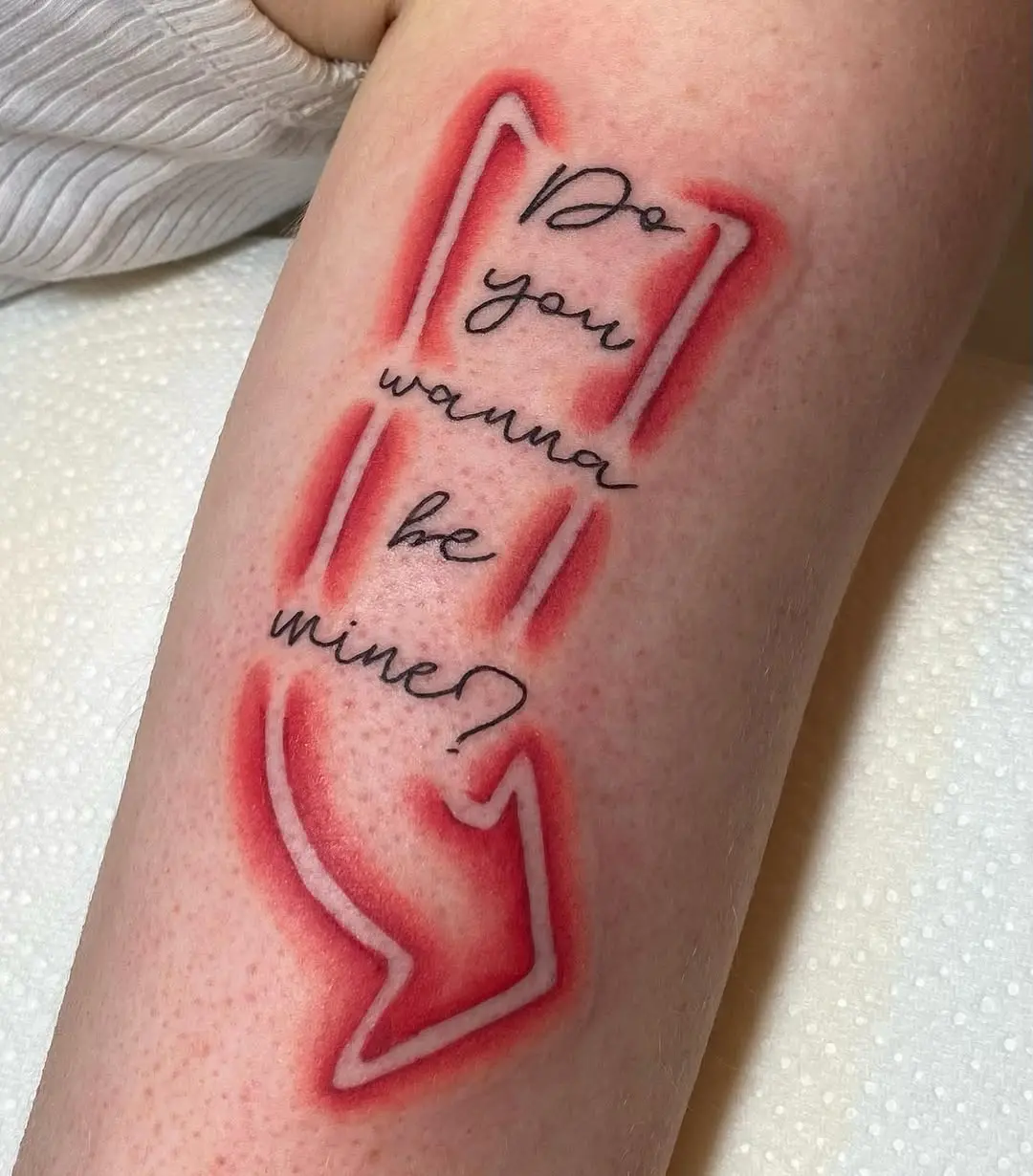 Text tattoo with a vibrant neon arrow design