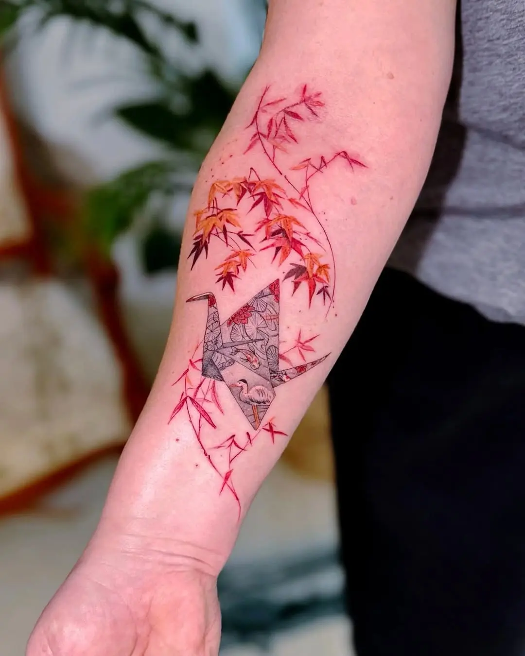Elegant origami crane tattoo with autumn foliage