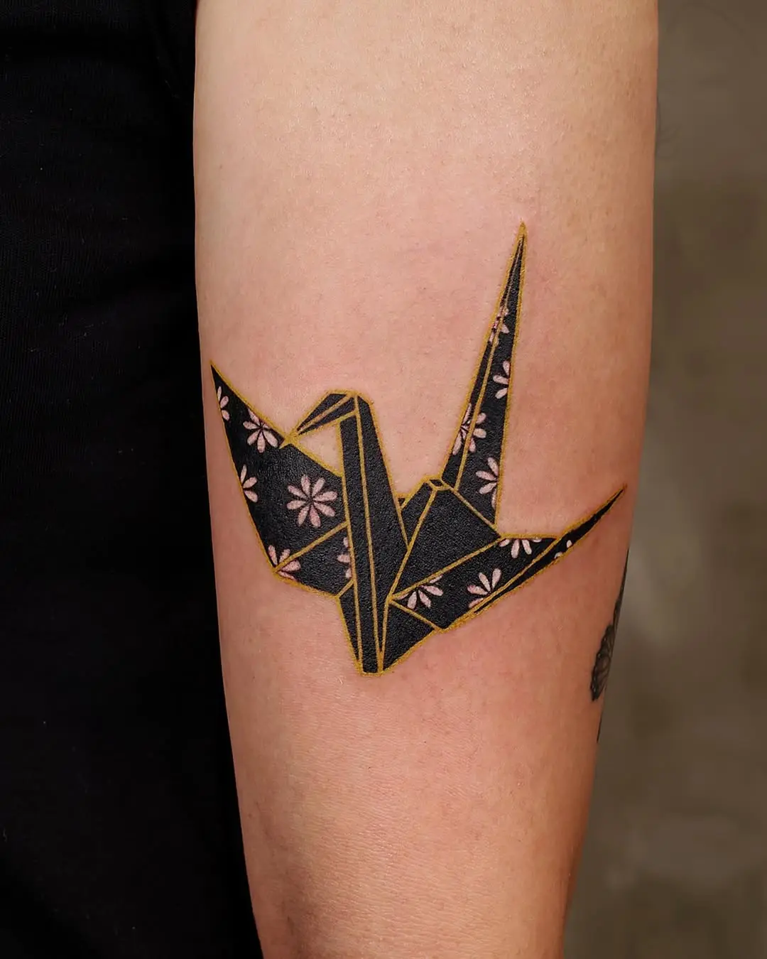 Elegant origami crane tattoo with floral details