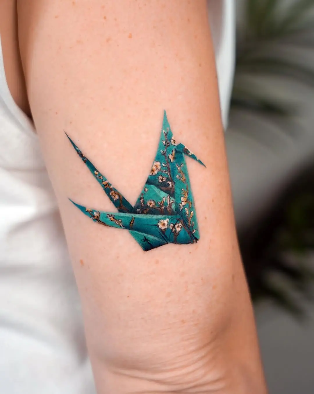 Intricate origami crane tattoo with floral detail