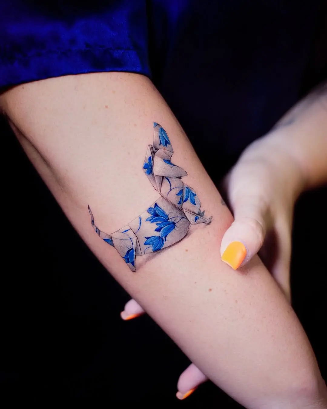 Elegant origami-inspired dog tattoo with flowers
