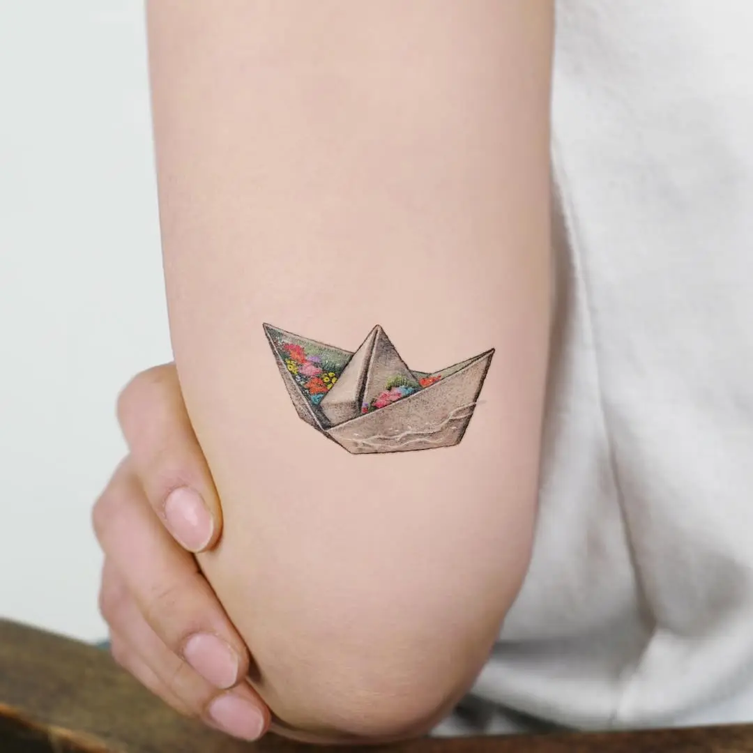 Elegant Origami Boat Tattoo with Floral Touch