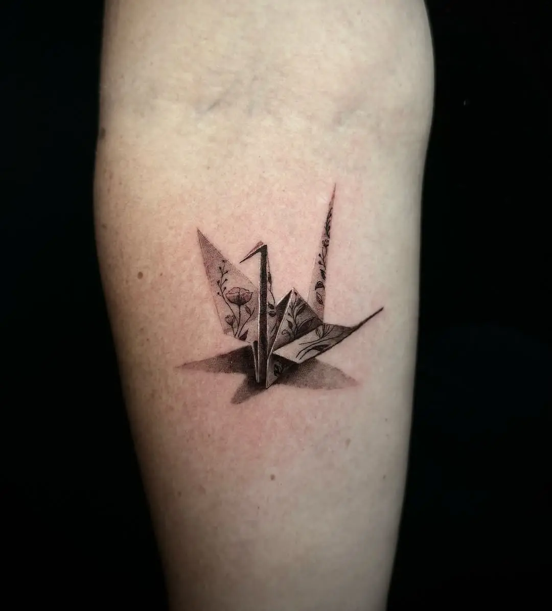 Elegant origami crane tattoo with floral details