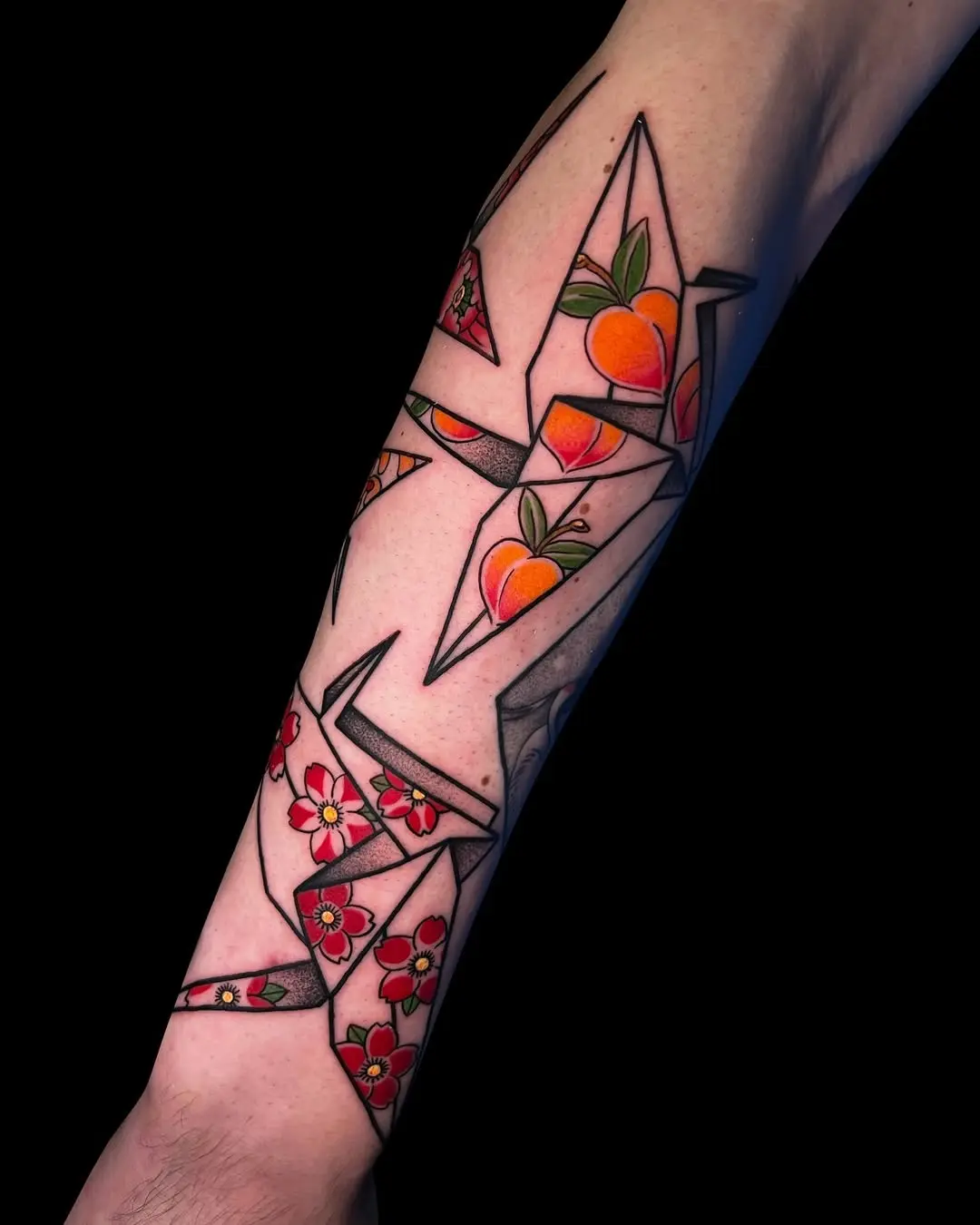 Colorful origami cranes tattoo adorns the arm