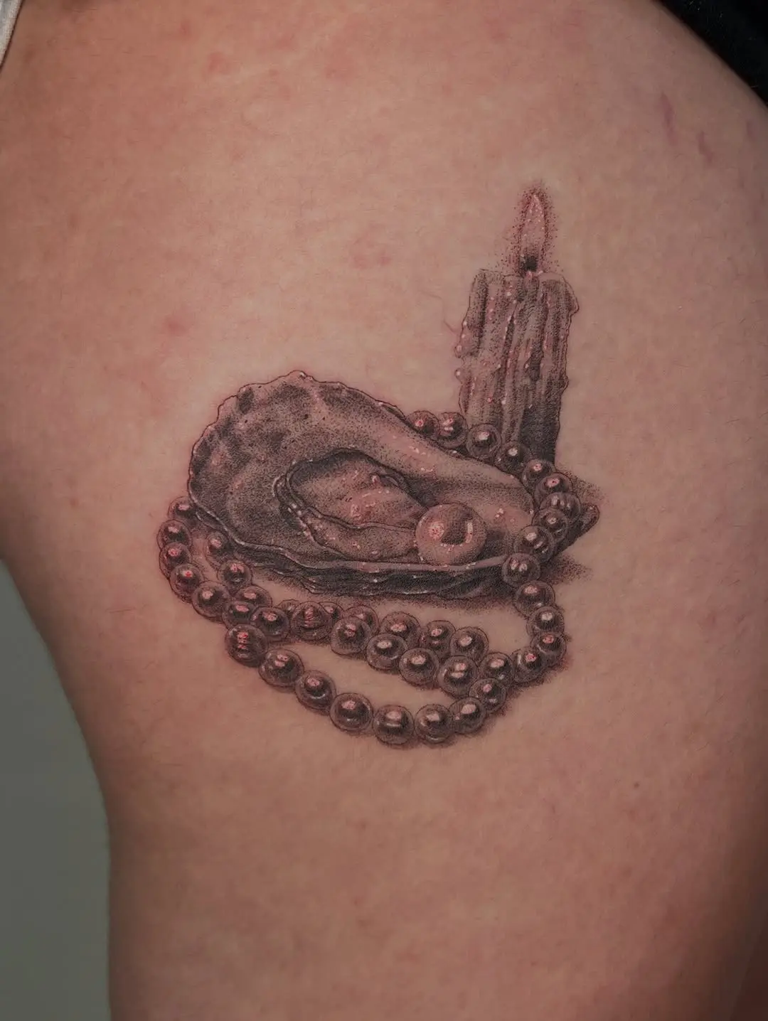 Detailed oyster tattoo showcasing pearls and beads