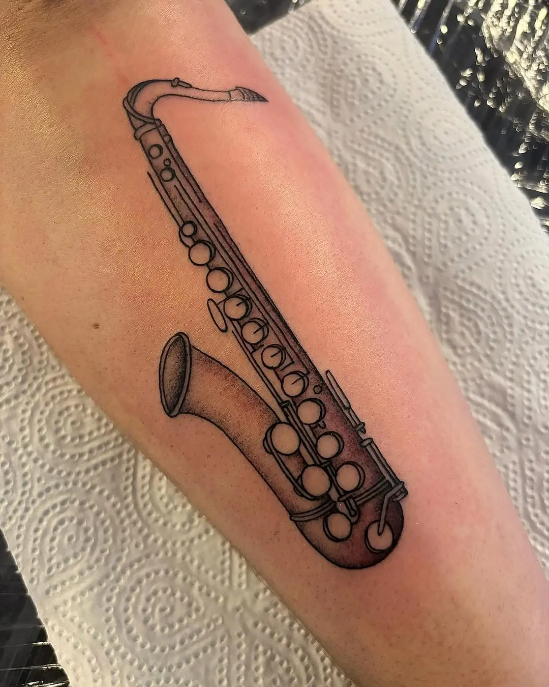 Elegant saxophone tattoo on forearm