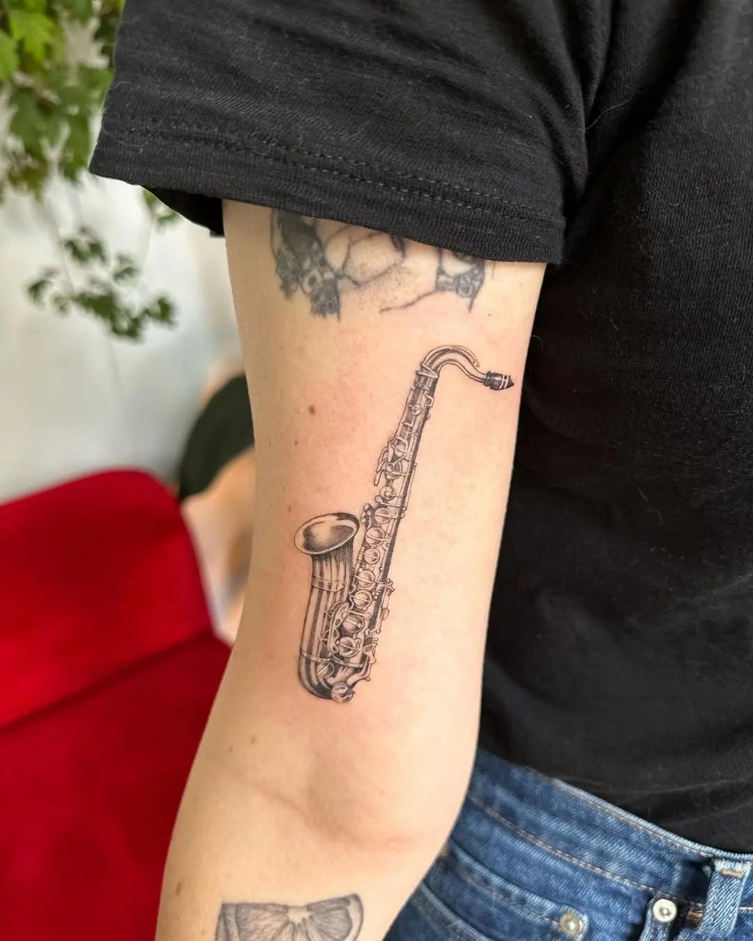 Elegant saxophone tattoo on forearm.