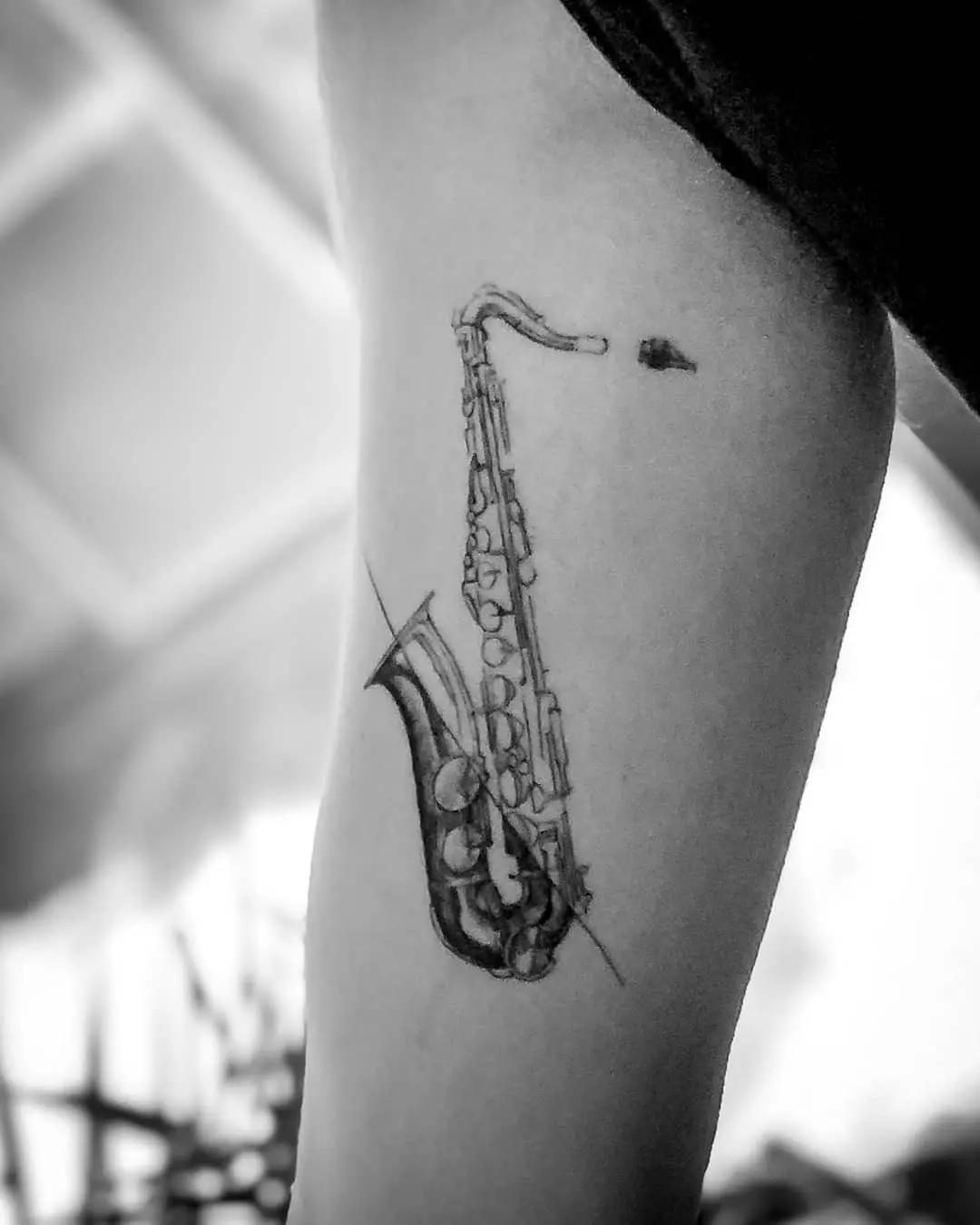 Intricate black and white saxophone tattoo design