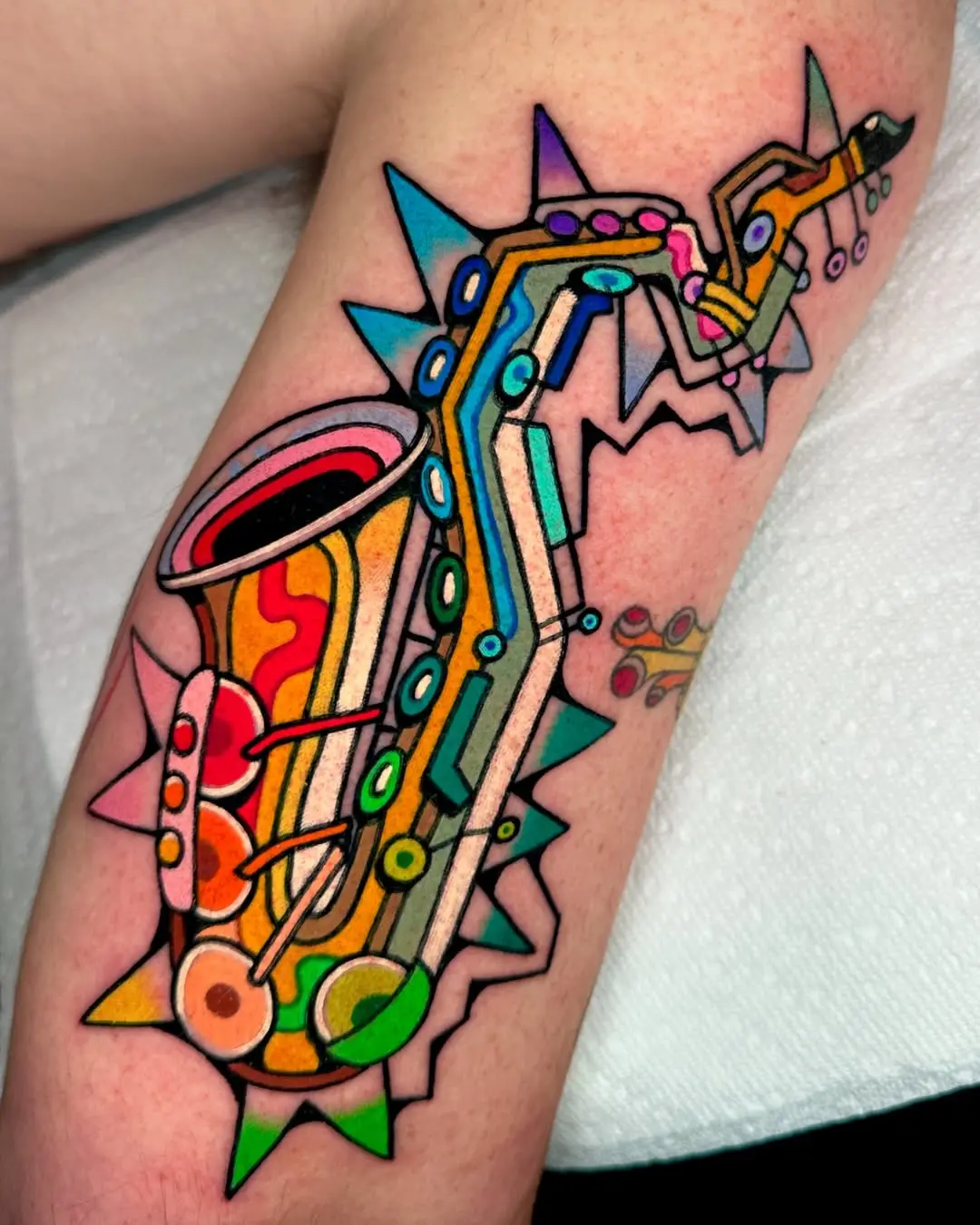 Vibrant saxophone tattoo bursting with color