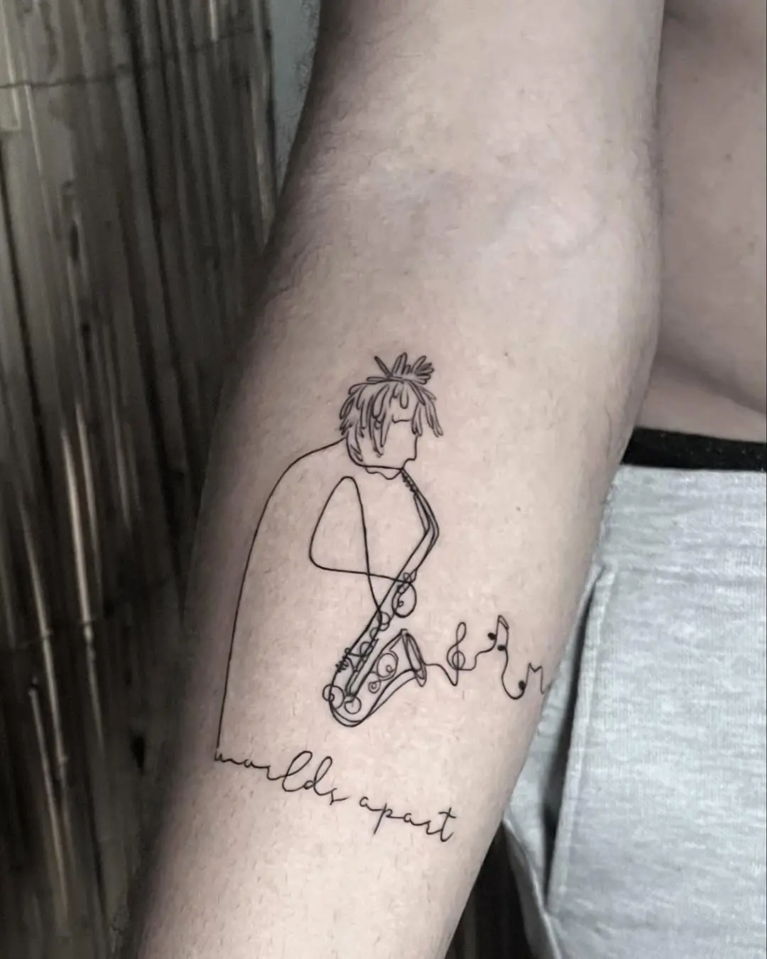 Minimalist saxophone tattoo with artistic flair