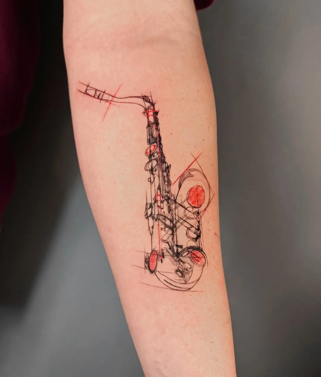 Artistic saxophone tattoo with bold red accents