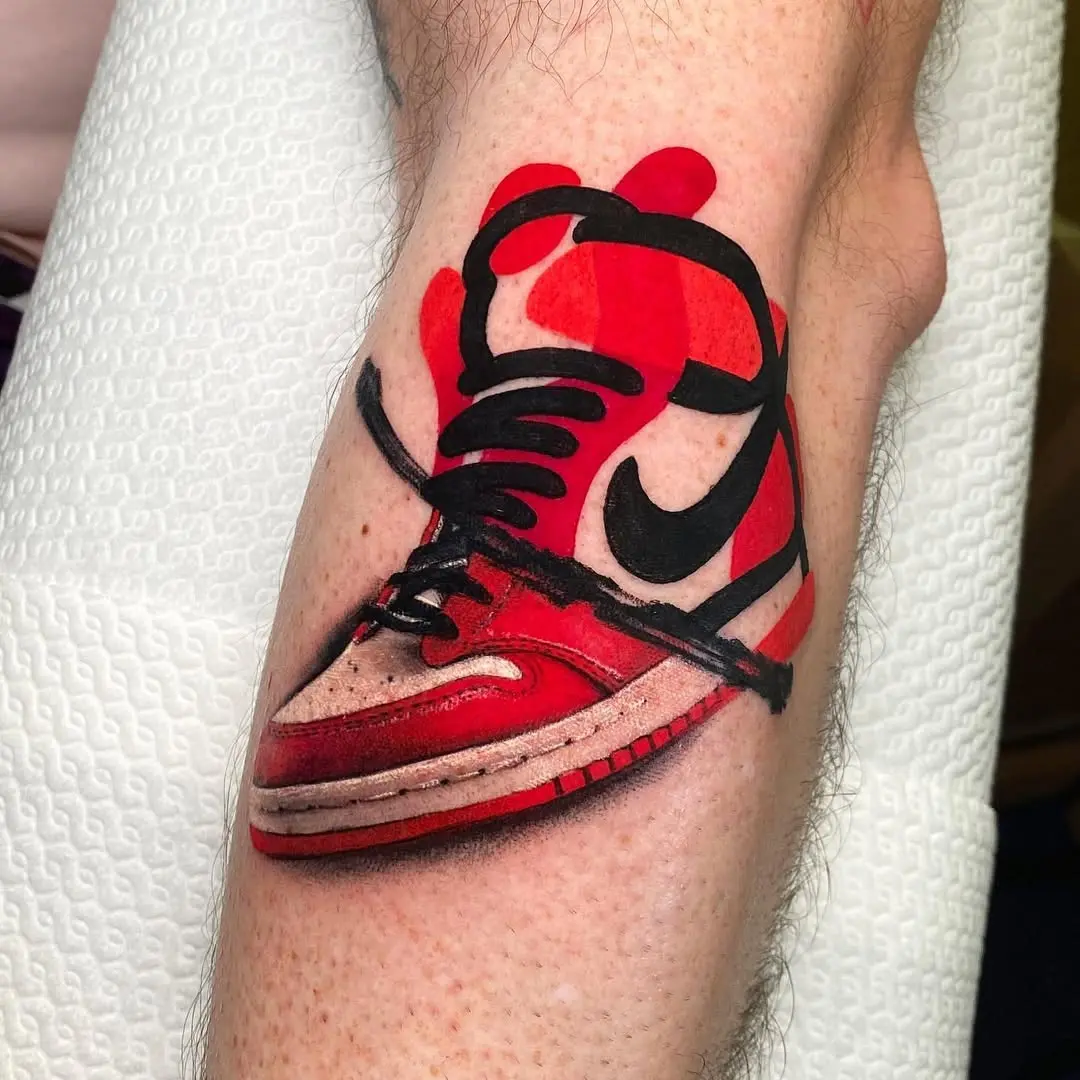 Vibrant red sneaker tattoo on calf
