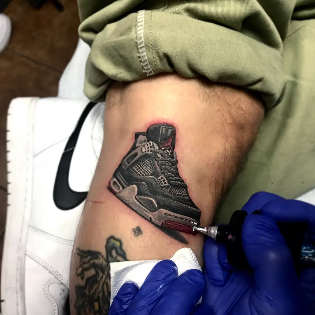 Artistic sneaker tattoo in progress on leg