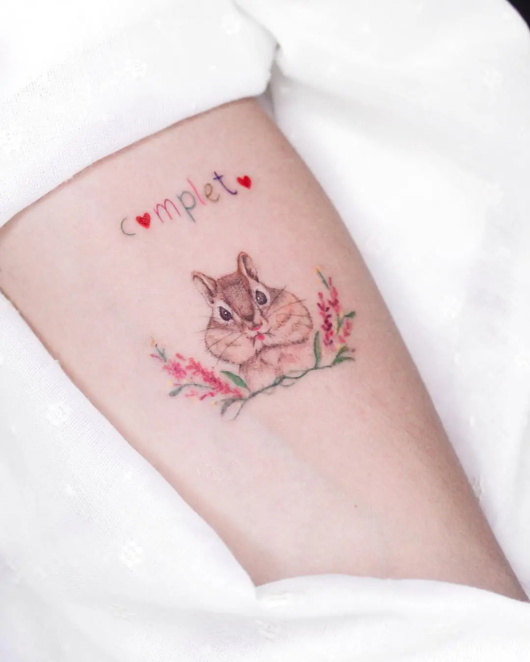 Charming squirrel tattoo with floral accents